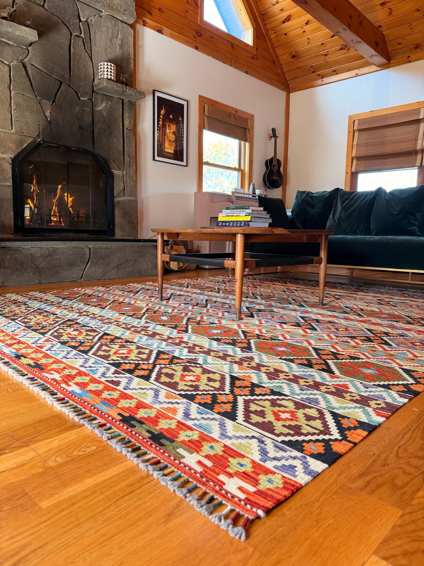 Living room with a colorful patterned rug, fireplace, and wooden coffee table.